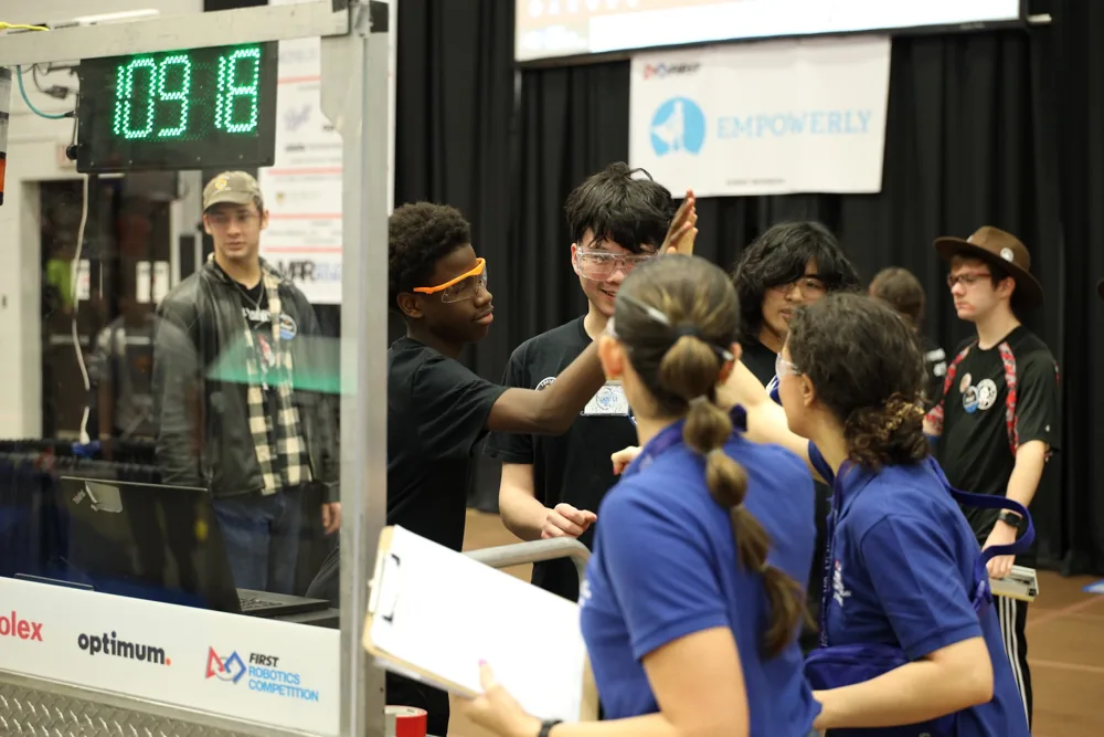 Students exchanging ideas with visitors in the Masterman Robotics competition pit